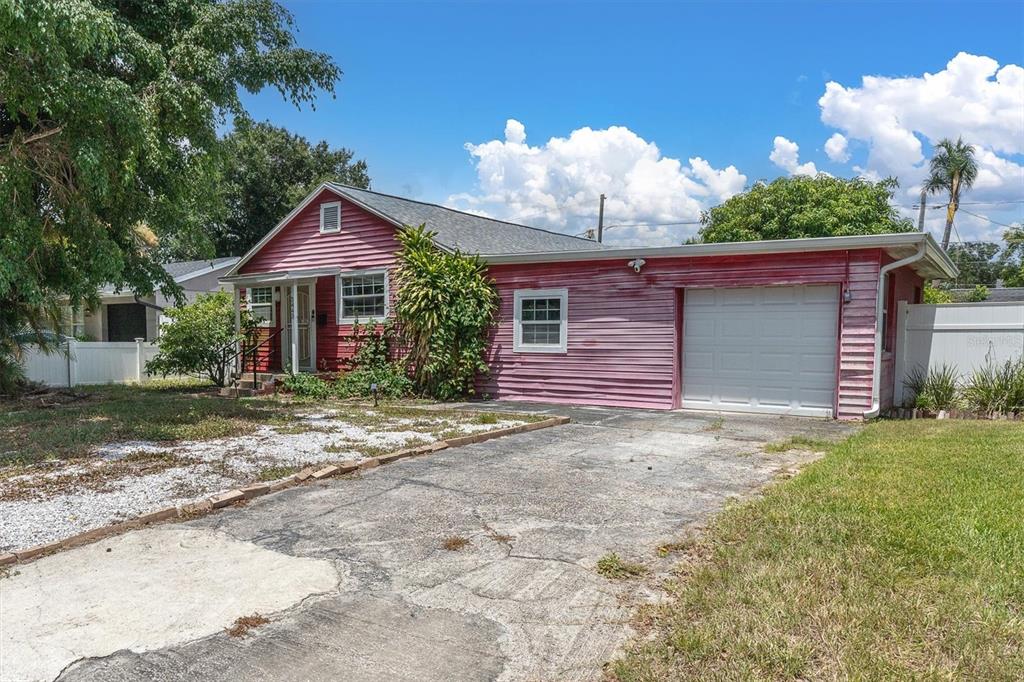 A pink, single-story house with a white garage door and a concrete driveway — 3443 21ST STREET N, ST PETERSBURG, FL