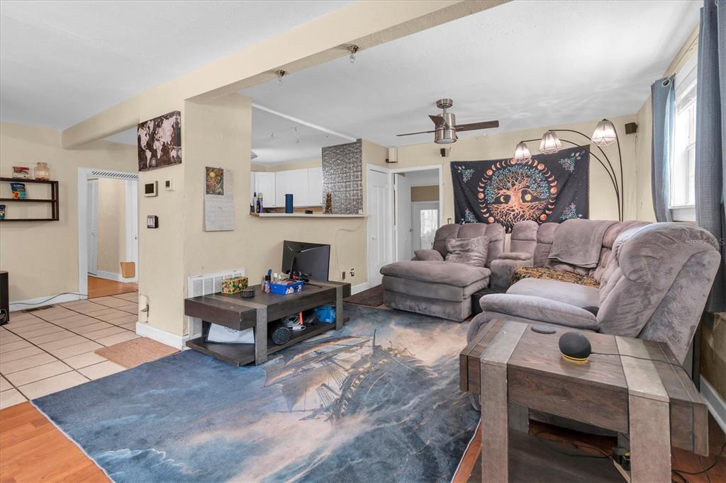 A living room features a gray sectional sofa, a ship-themed area rug, and a coffee table — 3443 21ST STREET N, ST PETERSBURG, FL