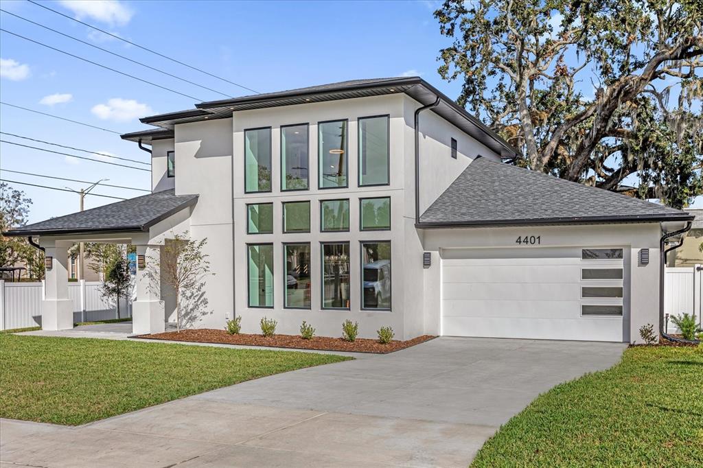 A modern two-story house with a white stucco exterior, dark trim, and a two-car garage — 4401 ROCKLEDGE ROAD, ORLANDO, FL