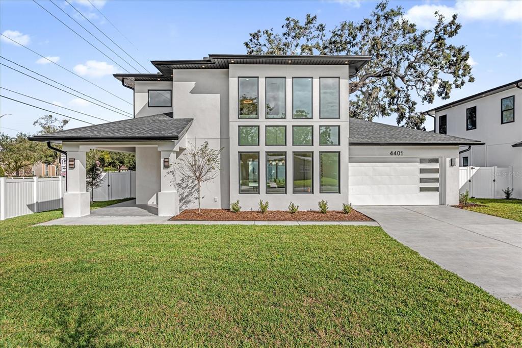 A modern two-story house with a white stucco exterior, large windows, and a concrete driveway — 4401 ROCKLEDGE ROAD, ORLANDO, FL