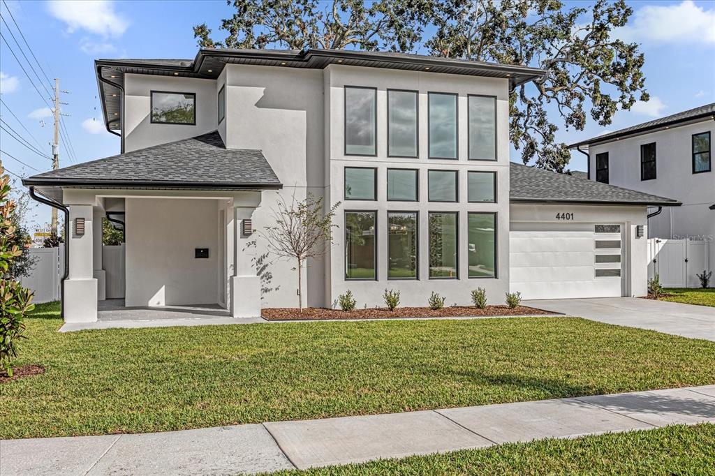 A modern two-story house with a white stucco exterior, large windows, and a two-car garage — 4401 ROCKLEDGE ROAD, ORLANDO, FL