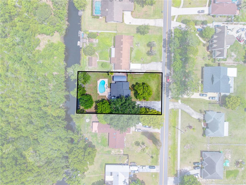 This aerial view shows a residential property with a swimming pool and a backyard — 6137 BASS HIGHWAY, ST CLOUD, FL