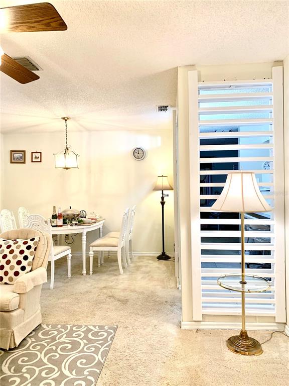 A dining area with a white table and chairs sits beside a room divider screen — 1891 FORTUNE COURT, DELTONA, FL