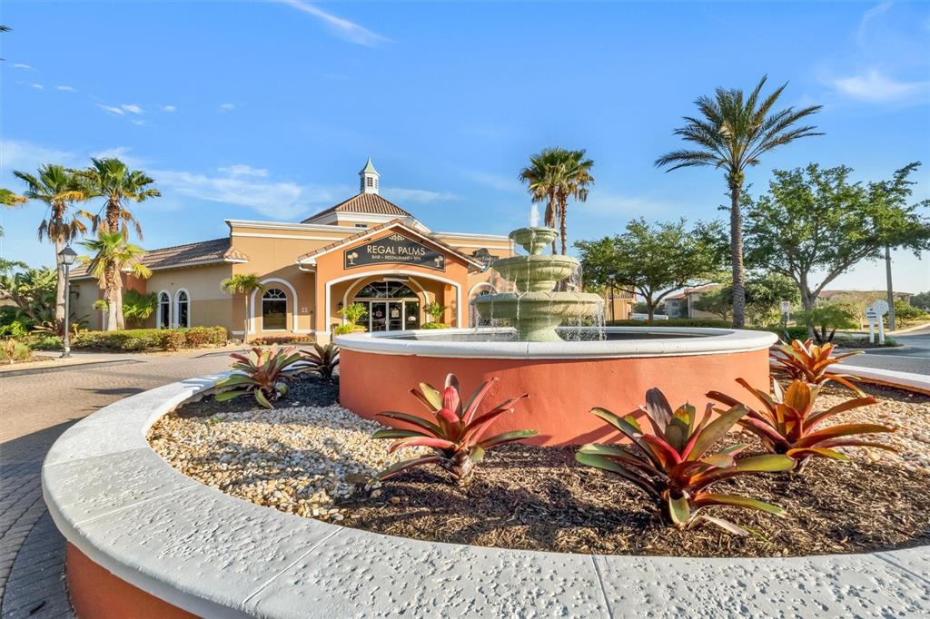 A tiered fountain sits in a circular planter in front of a tan resort building — 3001 CALABRIA AVENUE, DAVENPORT, FL