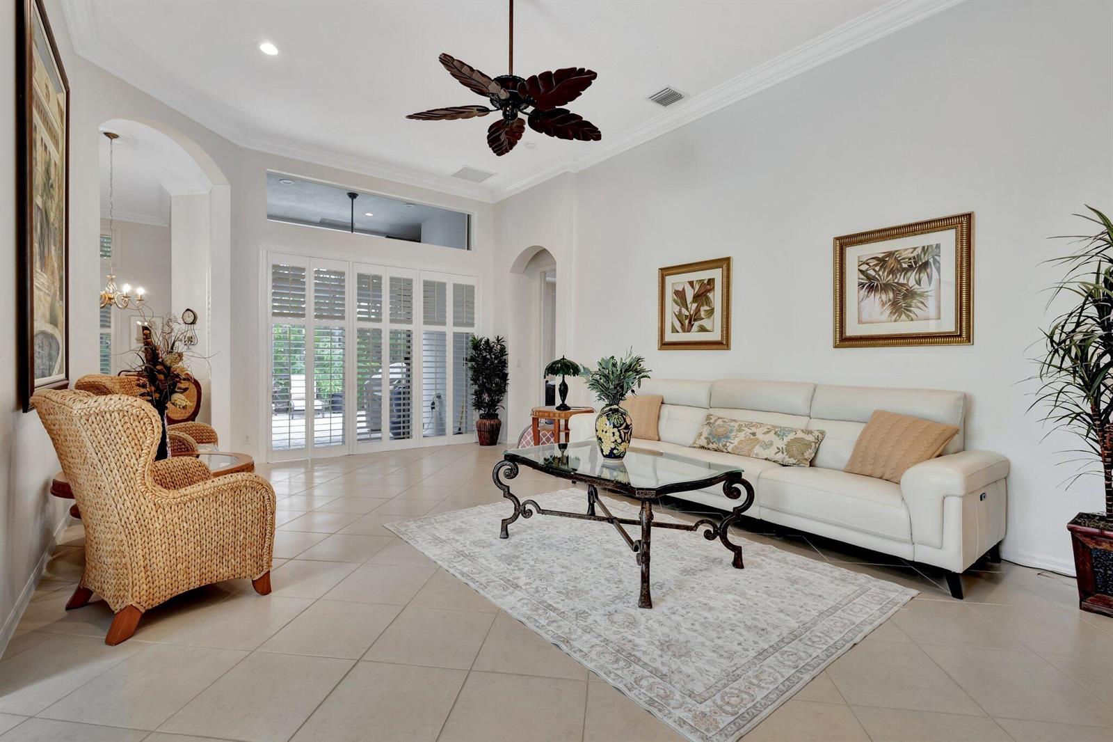 A living room features tile floors, a white sofa, wicker armchairs, and a ceiling fan — 10732 Grande Boulevard, West Palm Beach FL 33412, WEST PALM BEACH, FL