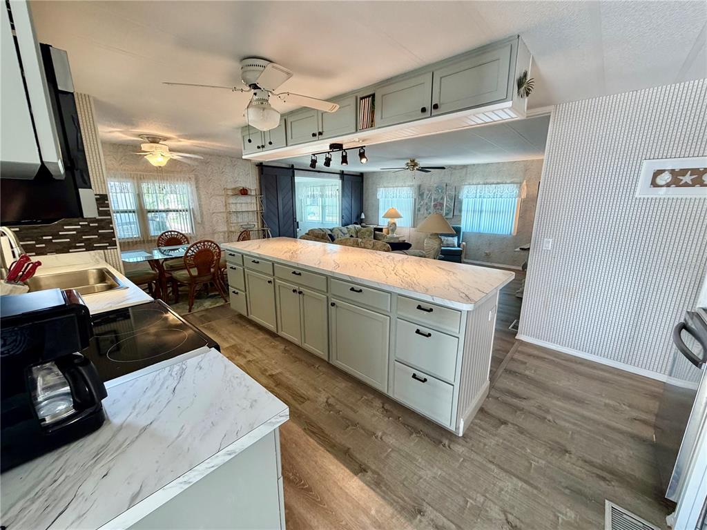 A kitchen with a large island, light green cabinets, and marble-look countertops — 34540 VIOLET DRIVE N, PINELLAS PARK, FL