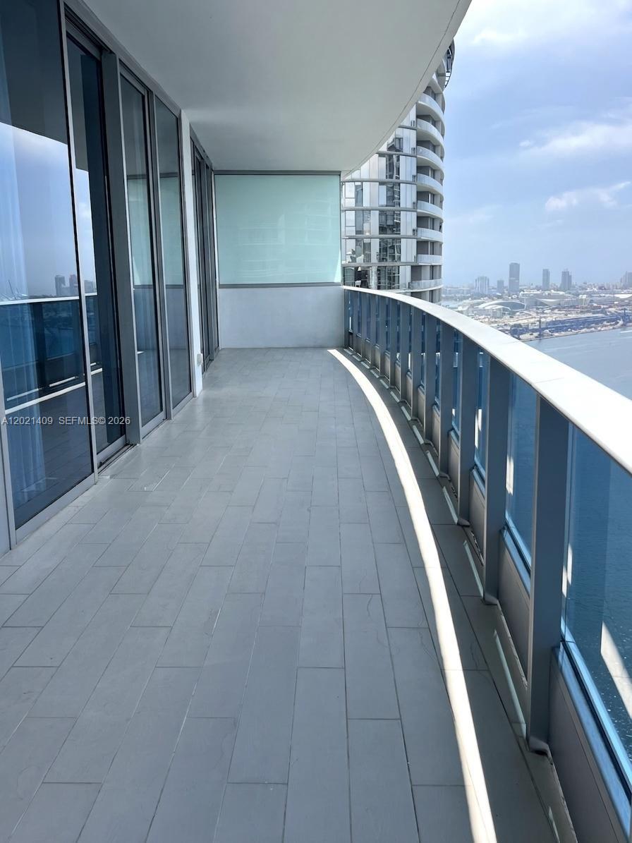 A high-rise balcony overlooks a city skyline and a body of water — 200 Biscayne Boulevard Way # 5004, Miami FL 33131, MIAMI, FL