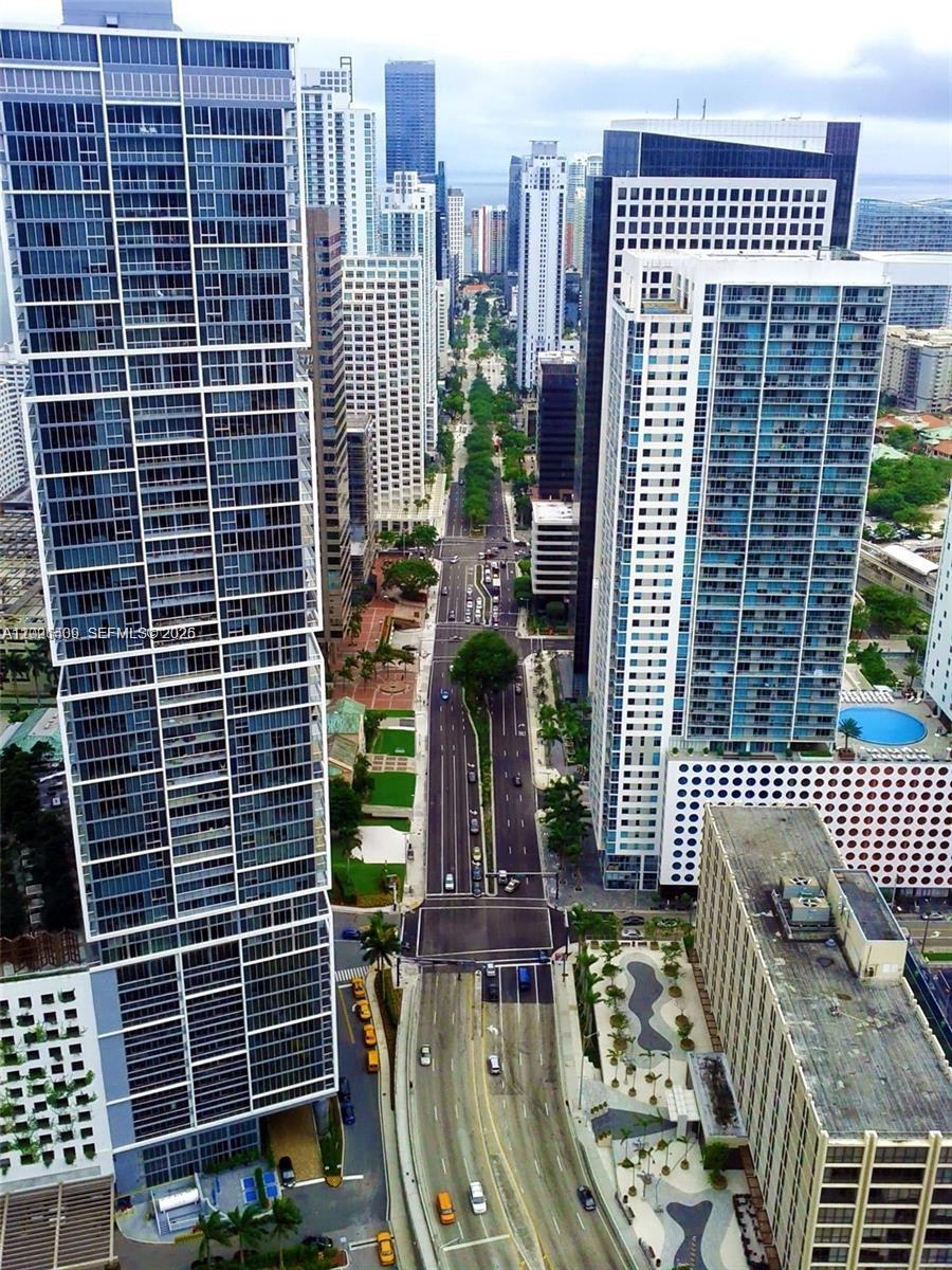 A curved balcony with gray tile flooring overlooks a city skyline and a body of water — 200 Biscayne Boulevard Way # 5004, Miami FL 33131, MIAMI, FL