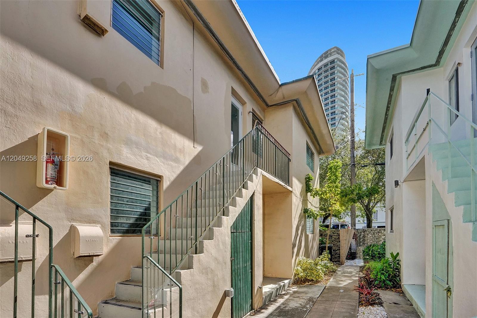 An exterior view of a two-story apartment building with outdoor staircases and a walkway — 1430 16th St # 1, Miami Beach FL 33139, MIAMI BEACH, FL