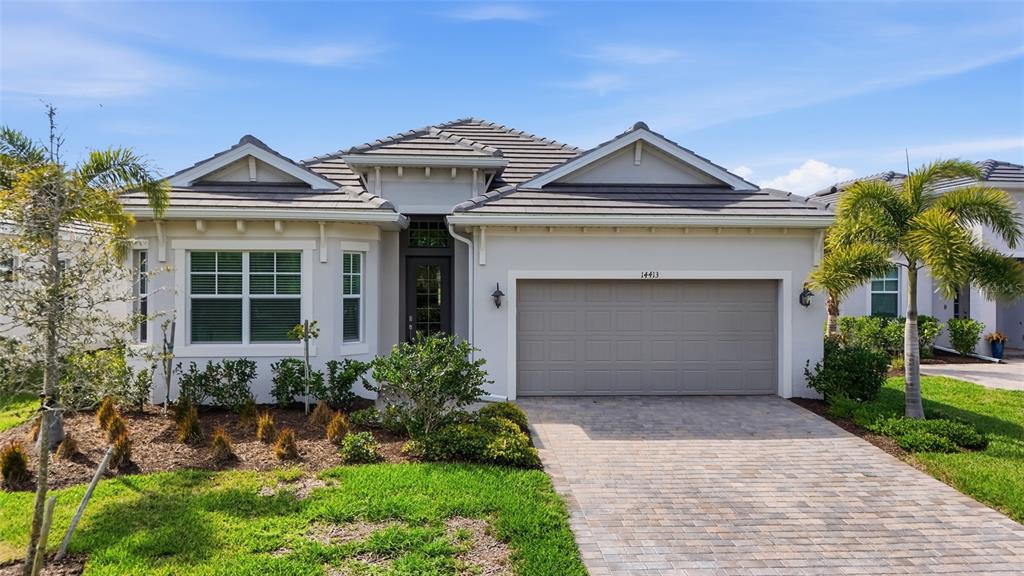A single-story house with a gray tiled roof, stucco exterior, and a paved driveway — 14413 HERITAGE LANDING BOULEVARD, PUNTA GORDA, FL