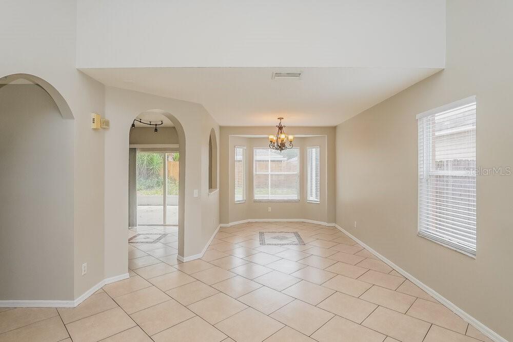 A dining area with tile flooring, a bay window, and a chandelier — 12723 ADVENTURE DRIVE, RIVERVIEW, FL