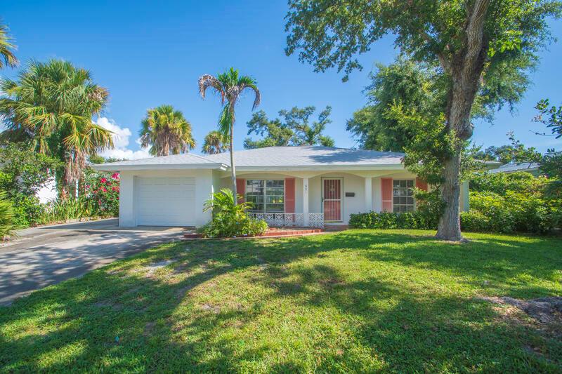 A single-story white house with a garage, palm trees, and a green lawn — VERO BEACH, FL