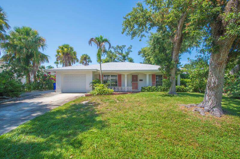 A single-story house with a white exterior, a one-car garage, and a large front lawn — VERO BEACH, FL