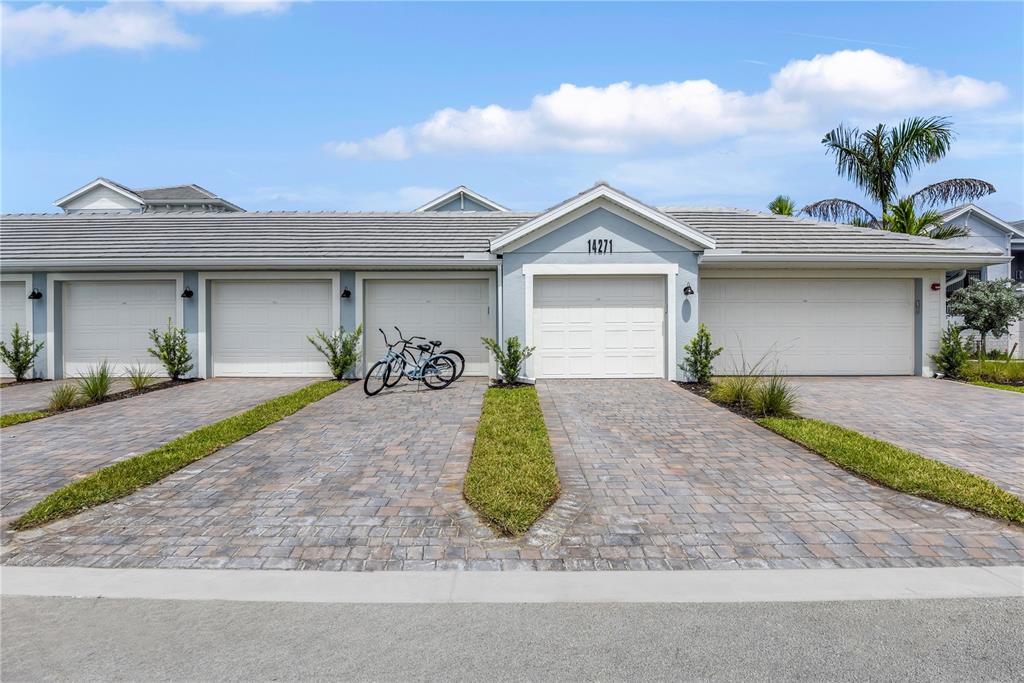 A row of attached garages with paved driveways and a bicycle parked in front — 14271 HERITAGE LANDING BOULEVARD UNIT 1527, PUNTA GORDA, FL