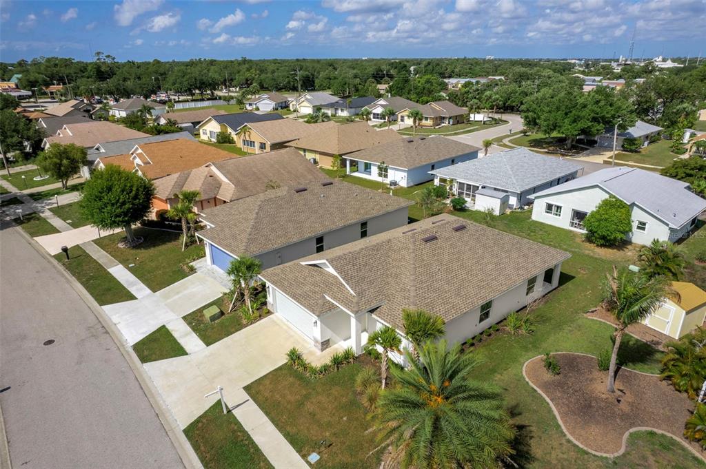 An aerial view of a suburban neighborhood featuring single-family homes with shingled roofs — 475 WINWOOD COURT, PORT CHARLOTTE, FL