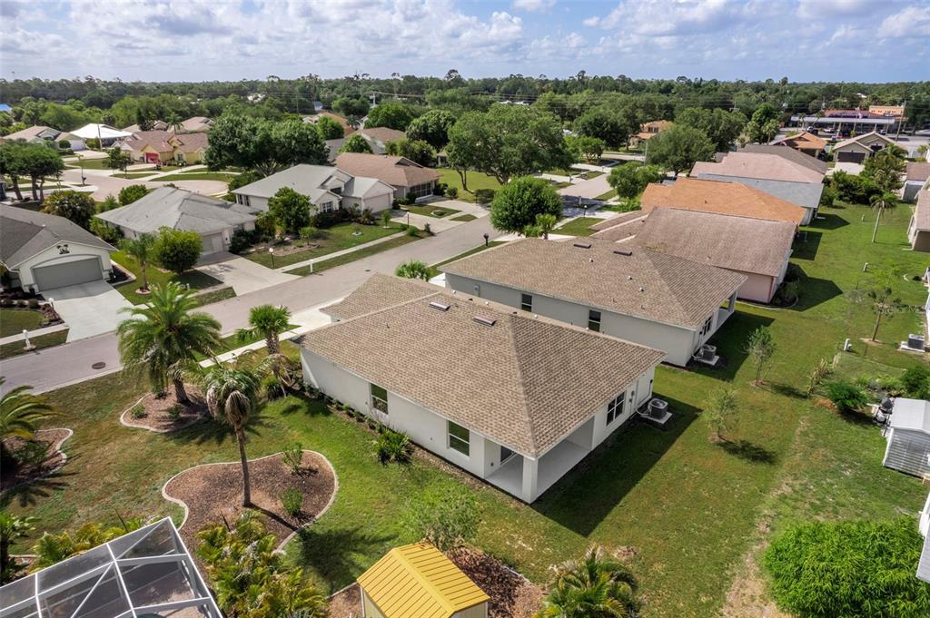 An aerial view shows suburban houses with shingled roofs and lawns in a residential neighborhood — 475 WINWOOD COURT, PORT CHARLOTTE, FL