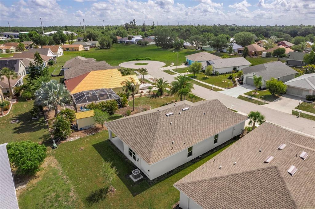 An aerial view shows suburban houses with shingled roofs and surrounding green lawns — 475 WINWOOD COURT, PORT CHARLOTTE, FL