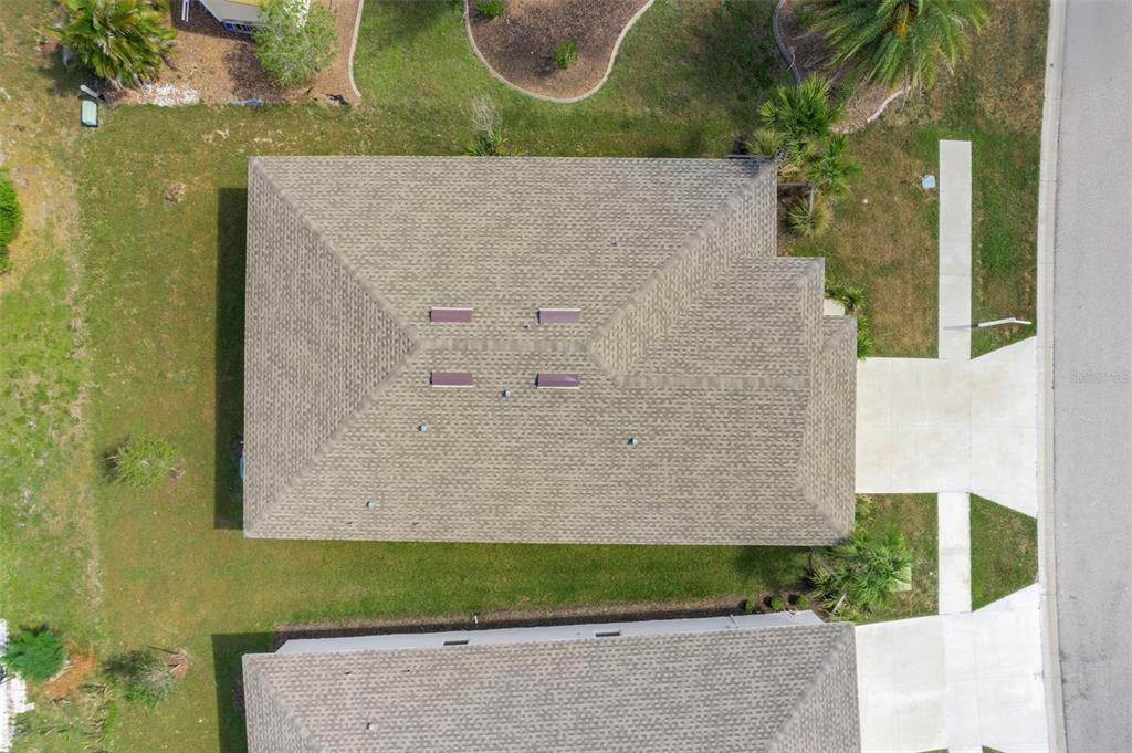 An aerial view shows the shingled roof of a house with four skylights — 475 WINWOOD COURT, PORT CHARLOTTE, FL