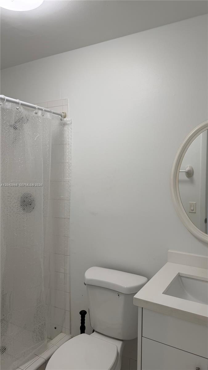 A bathroom features a white vanity, a toilet, and a shower with a clear curtain — 612 NW 43rd Ct # 0, Miami FL 33126, MIAMI, FL