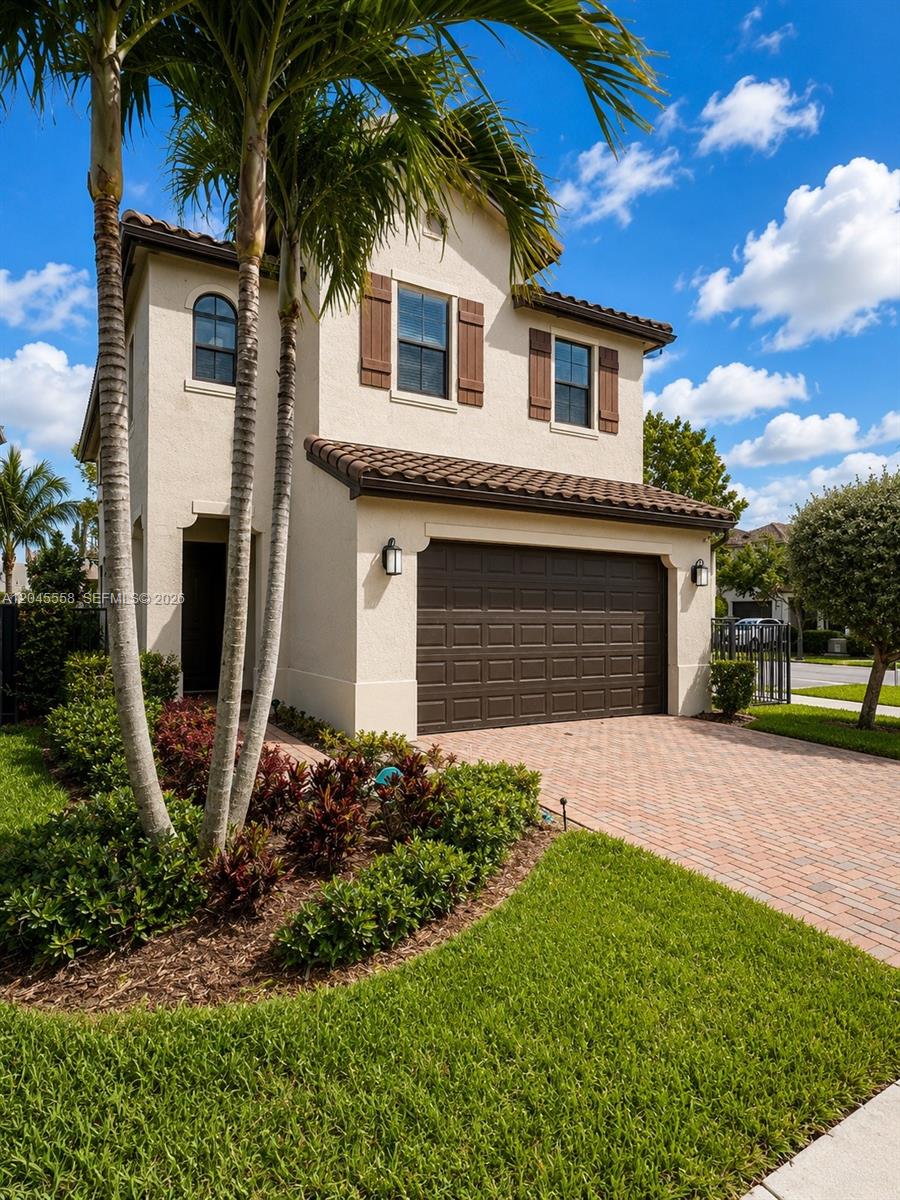 A two-story stucco house features a brown garage door, tiled roof, and palm trees — 3209 W 98th Pl, Hialeah FL 33018, HIALEAH, FL