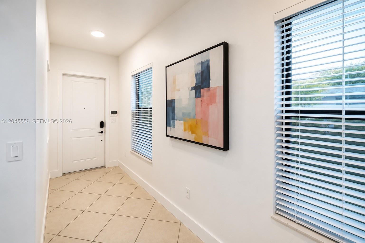 A modern living room features a large television console, beige sofa, and sliding glass doors — 3209 W 98th Pl, Hialeah FL 33018, HIALEAH, FL