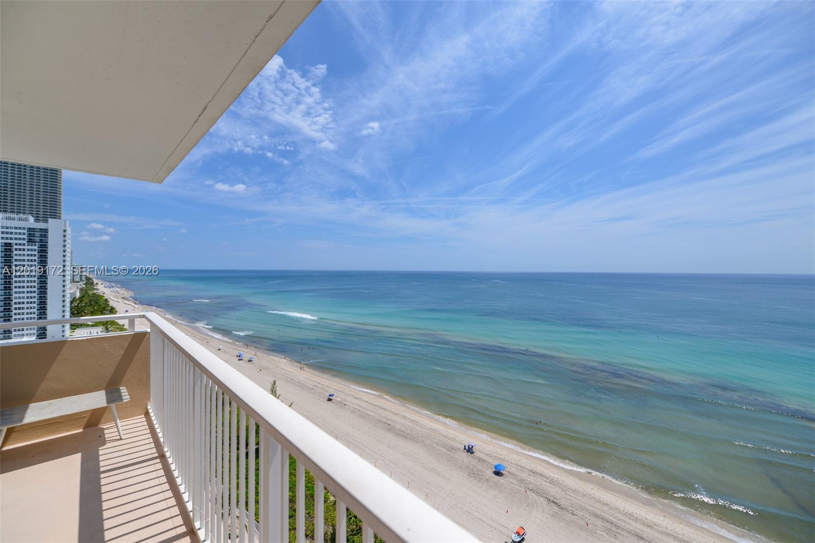 A high-angle view of a balcony overlooking a sandy beach and the ocean — 1950 S Ocean Dr # 15P, Hallandale Beach FL 33009, HALLANDALE BEACH, FL