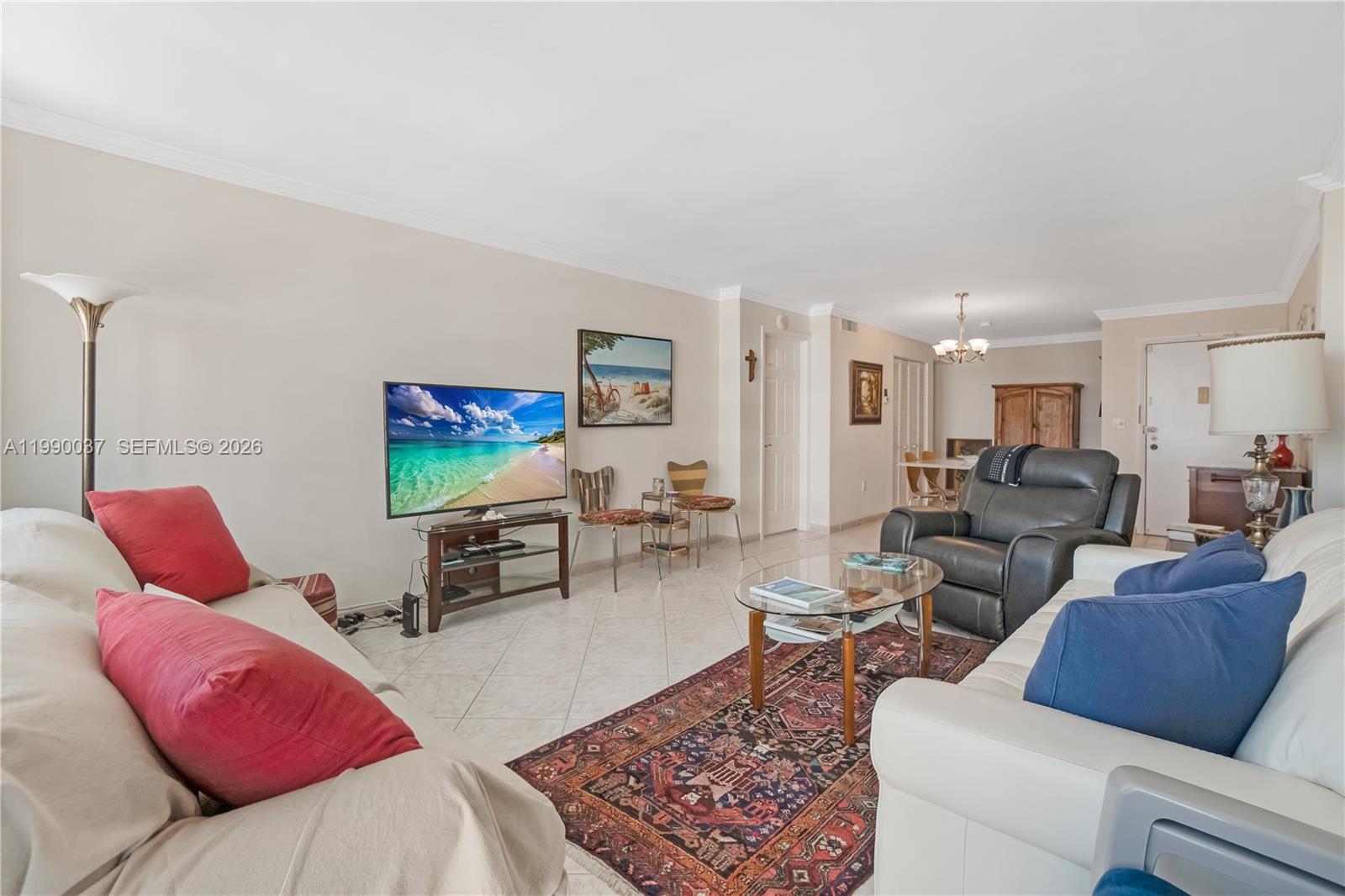 A living room features a white sofa with red pillows, a leather recliner, and tile flooring — 245 18th St # 904, Miami Beach FL 33139, MIAMI BEACH, FL