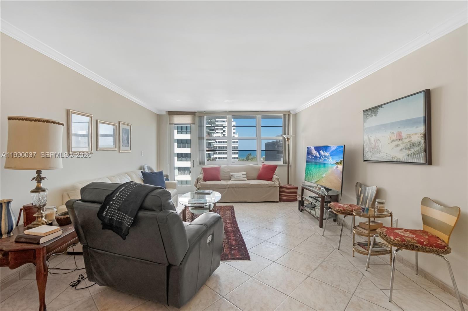 A living room features tile flooring, a gray recliner, a sofa, and a television — 245 18th St # 904, Miami Beach FL 33139, MIAMI BEACH, FL