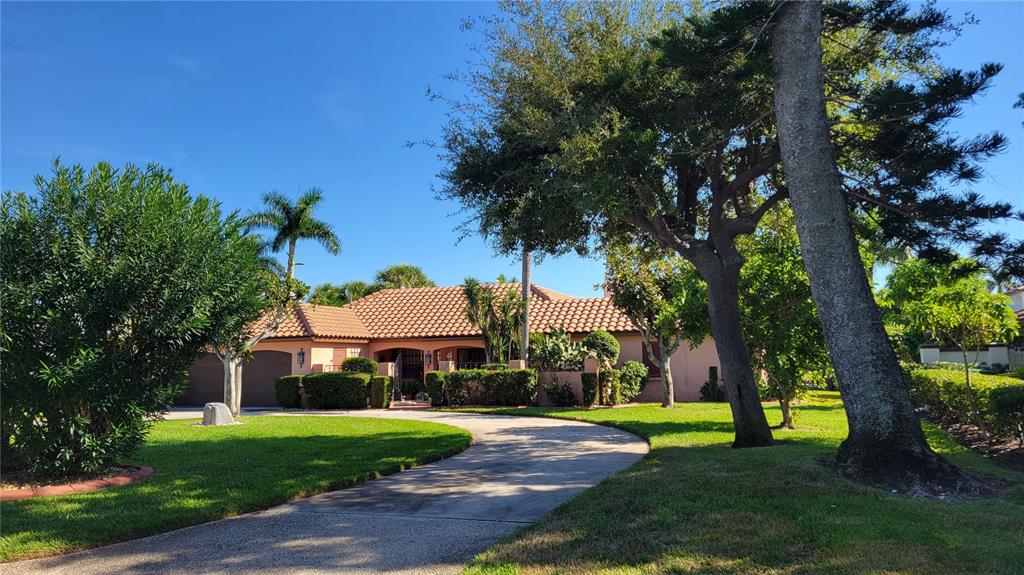 A single-story house with a tile roof and a curved driveway surrounded by mature trees — 638 S OWL DRIVE, SARASOTA, FL