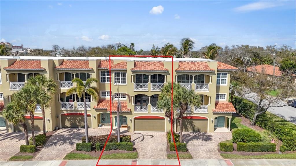 An exterior view of a three-story townhouse with a garage and a tiled roof — 702 GRANADA AVENUE UNIT 7, VENICE, FL