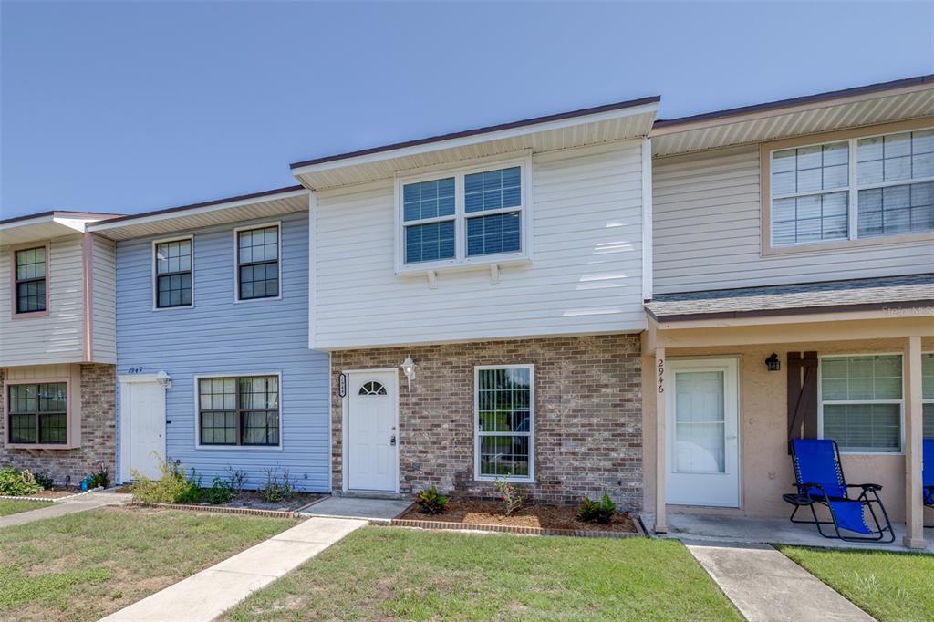 A row of three attached townhouses with brick and vinyl siding exteriors under a clear sky — 2944 MORGAN COMBEE ROAD, LAKELAND, FL