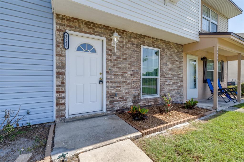 The exterior view shows a brick and siding townhouse entrance with a white front door — 2944 MORGAN COMBEE ROAD, LAKELAND, FL