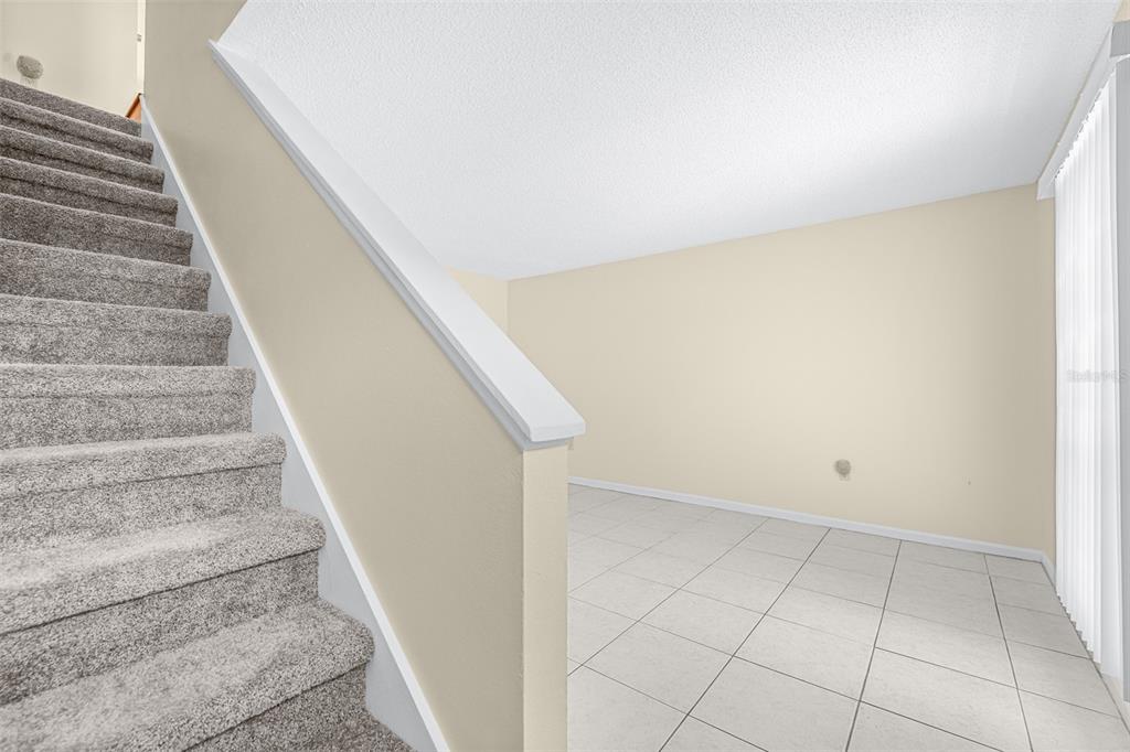 A carpeted staircase leads down to a room with light-colored tile flooring and walls — 2944 MORGAN COMBEE ROAD, LAKELAND, FL