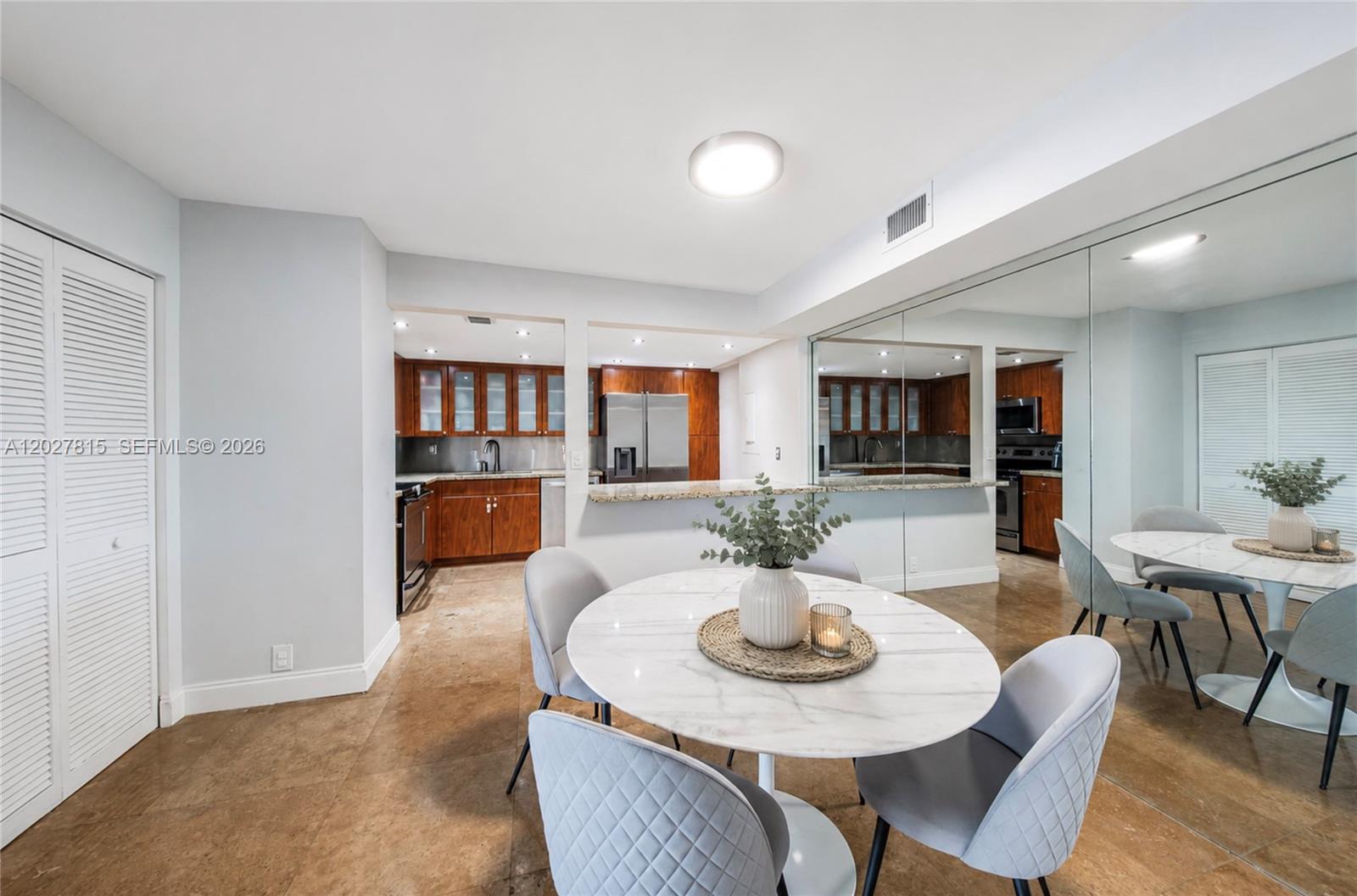 A dining area with a round marble table sits adjacent to an open kitchen — 4000 Towerside Ter # 604, Miami FL 33138, MIAMI, FL