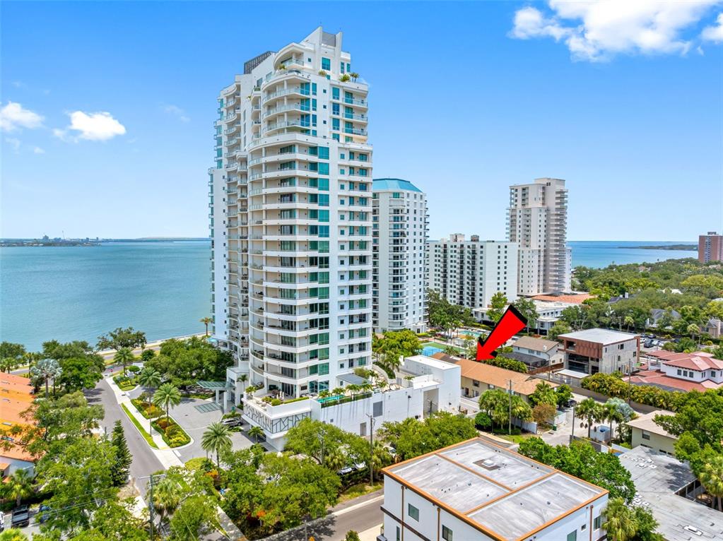 An aerial view shows a tall waterfront residential tower next to a low-rise building — 3420 S CARTER STREET UNIT C, TAMPA, FL