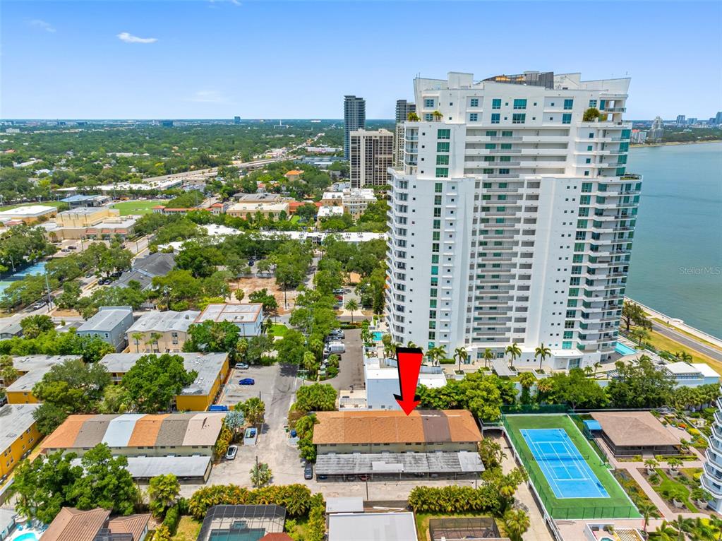 An aerial view shows a low-rise apartment building with a red arrow pointing toward it — 3420 S CARTER STREET UNIT C, TAMPA, FL