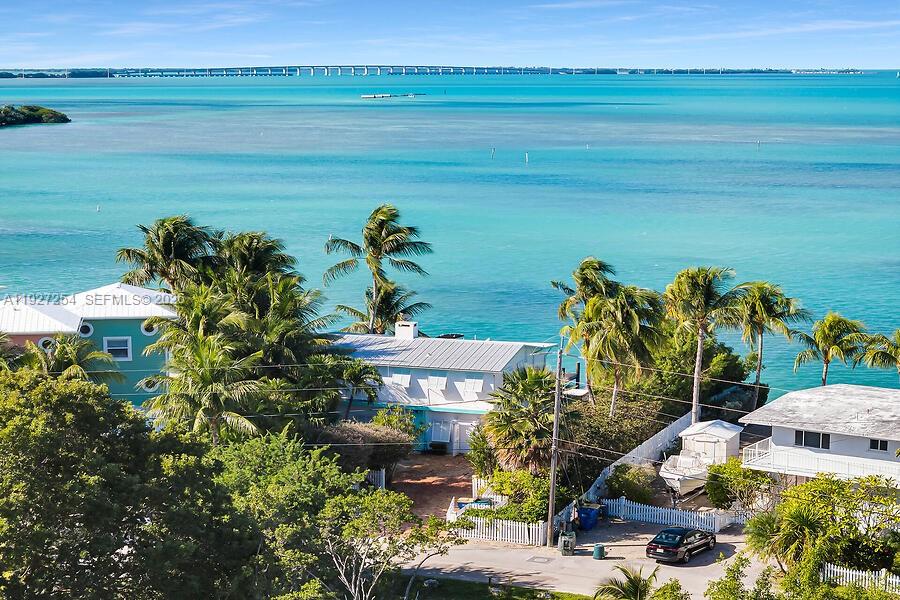An aerial view shows houses with palm trees near a turquoise bay and a bridge — 166 Bayview Drive, Islamorada FL 33036, ISLAMORADA, FL