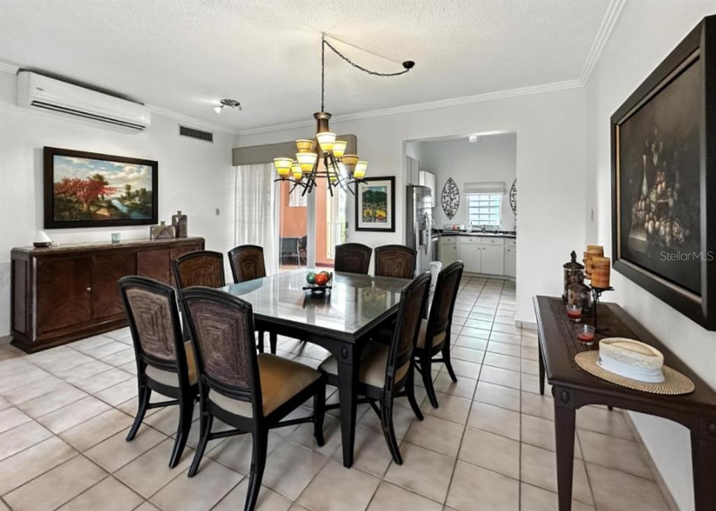A dining room features a glass-topped table, dark wood chairs, tile flooring, and a chandelier — Candelero Drive SE FAIRWAY COURTS - PALMAS DEL MAR COURTS N UNIT 734, HUMACAO, PR