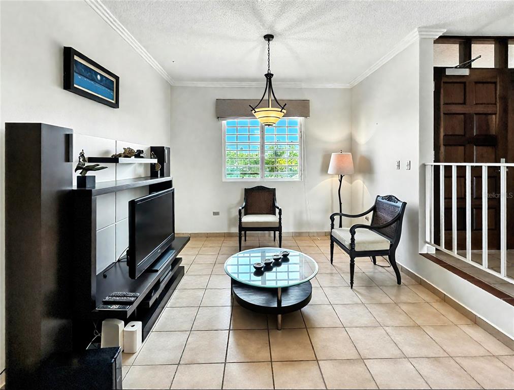 A living room features tile flooring, a glass coffee table, two chairs, and a television console — Candelero Drive SE FAIRWAY COURTS - PALMAS DEL MAR COURTS N UNIT 734, HUMACAO, PR