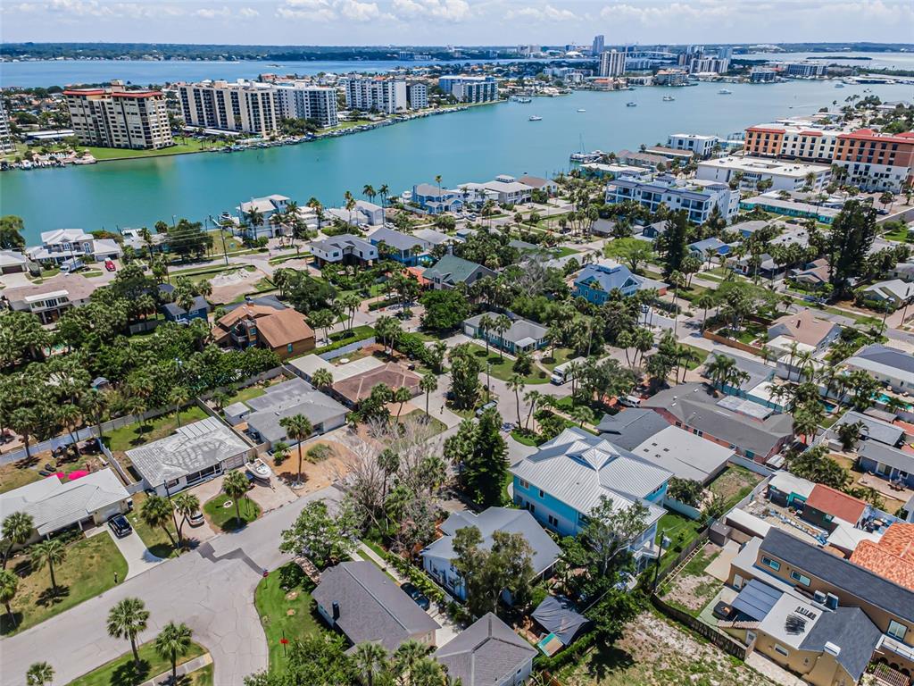 An aerial view shows a residential neighborhood situated along a waterfront with high-rise buildings — 720 BRUCE AVENUE, CLEARWATER BEACH, FL