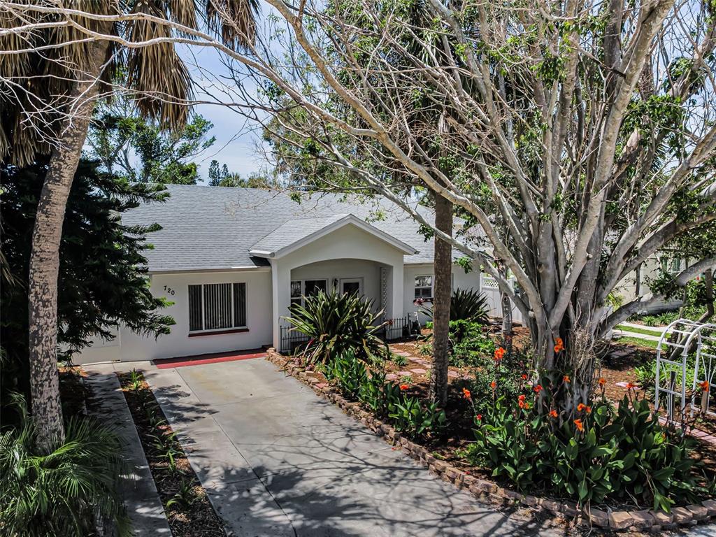 A single-story house with a white exterior, a gray roof, and a concrete driveway — 720 BRUCE AVENUE, CLEARWATER BEACH, FL