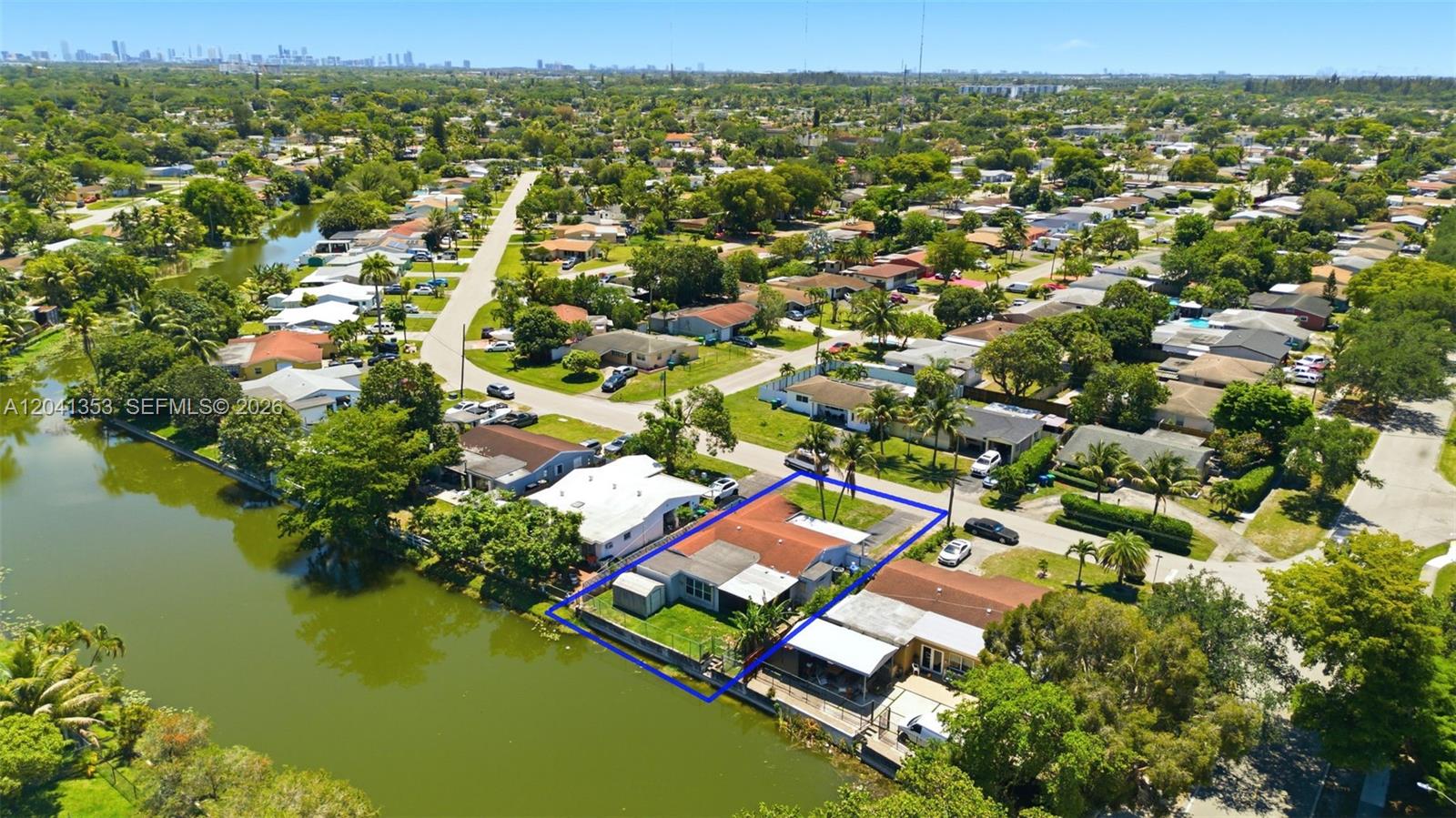 An aerial view shows a waterfront house with a red roof and a fenced yard — 6789 SW 27th Ct, Miramar FL 33023, MIRAMAR, FL