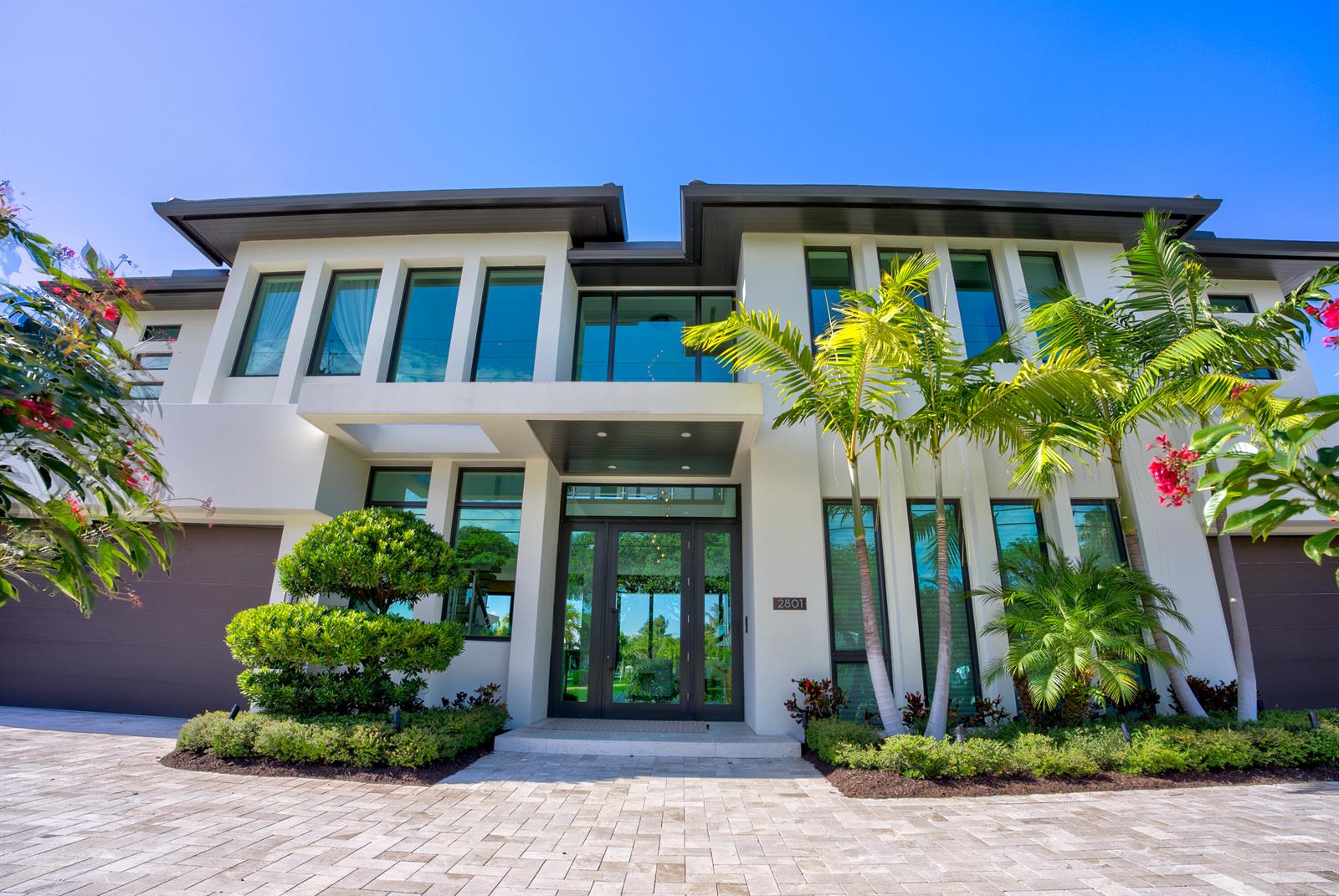 A modern two-story house exterior features a glass front entrance, palm trees, and paved driveway — 2801 NE 36th Street, Lighthouse Point FL 33064, LIGHTHOUSE POINT, FL
