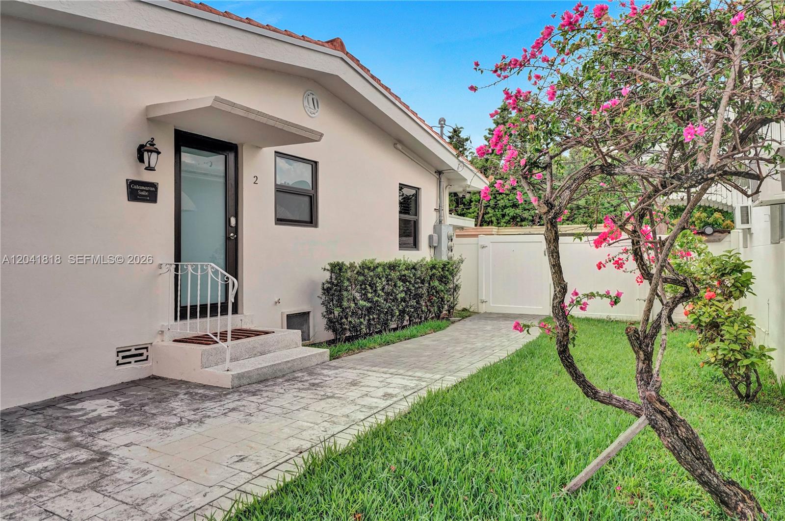 A paved walkway leads to the entrance of a building labeled Catamaran Suite — 1704 Rodman St, Hollywood FL 33020, HOLLYWOOD, FL