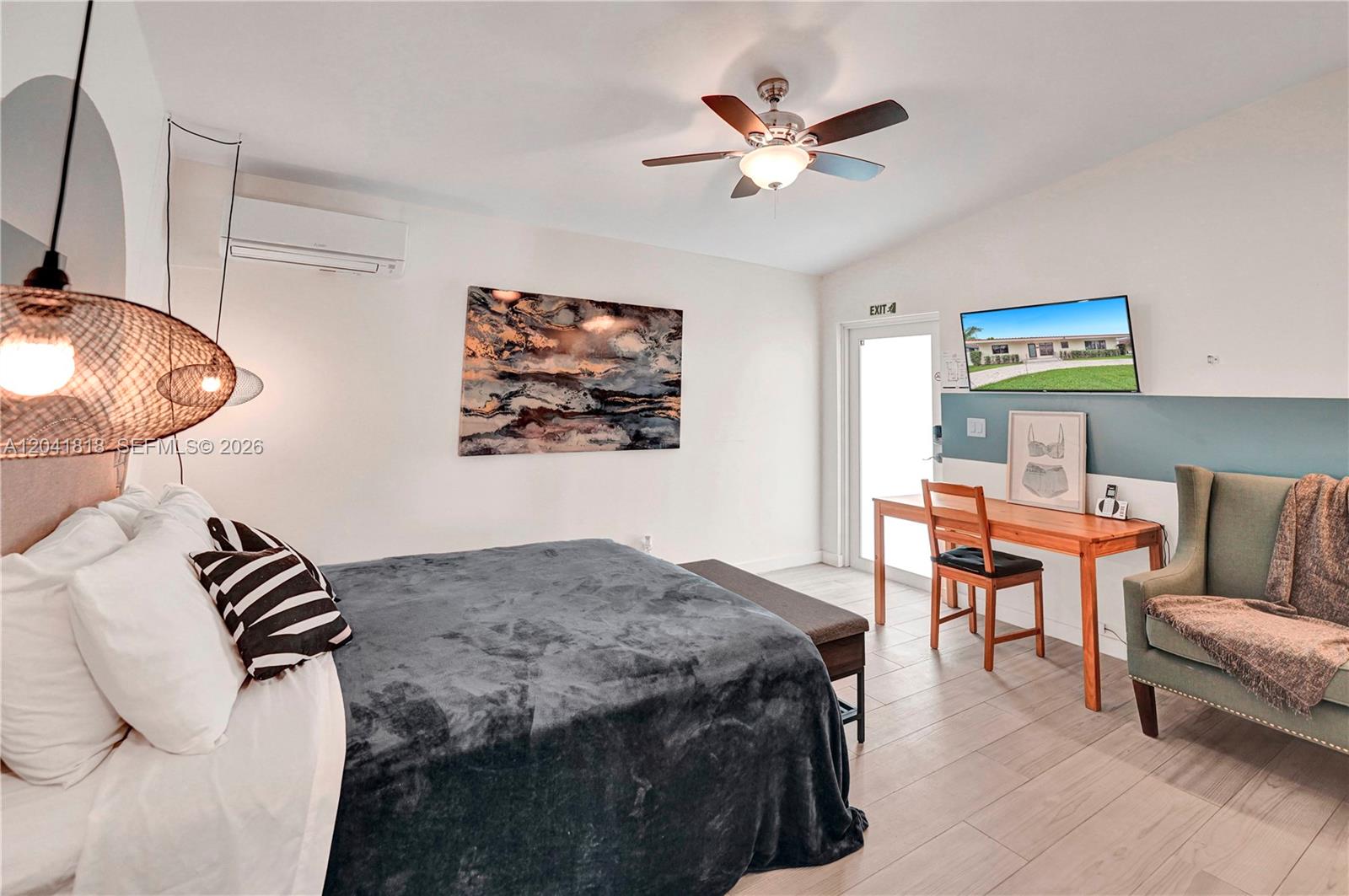 A bedroom features a bed, a desk with a chair, an armchair, and a ceiling fan — 1704 Rodman St, Hollywood FL 33020, HOLLYWOOD, FL