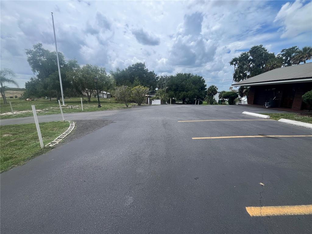 An asphalt parking lot sits in front of a building with a metal roof — 1145 S LAKE REEDY BOULEVARD, FROSTPROOF, FL