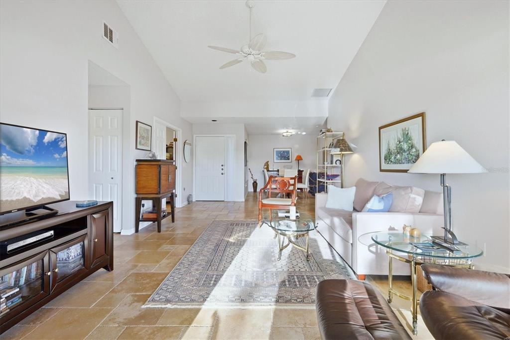 A living room features tile flooring, a vaulted ceiling with a fan, and a rug — 260 SOUTHAMPTON DRIVE UNIT 312, VENICE, FL