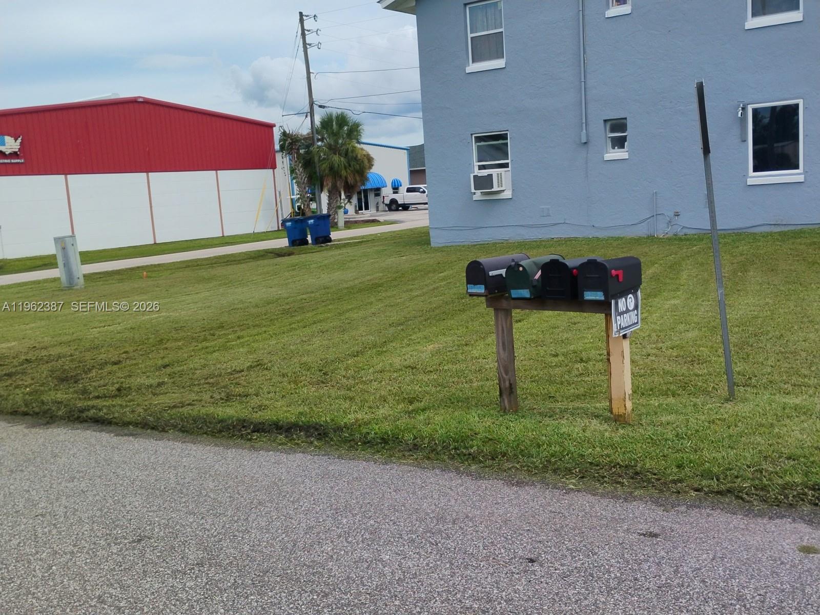 A row of four mailboxes stands on a wooden post in front of a building — 4131 Commercial Dr, Sebring FL 33870, SEBRING, FL