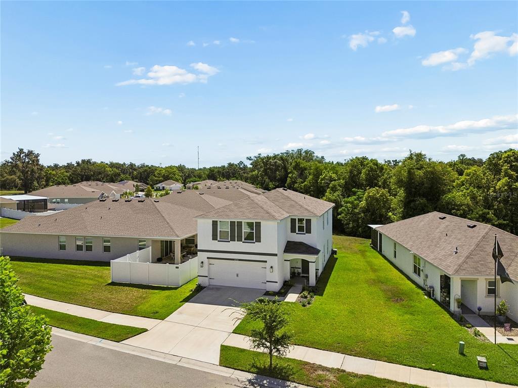 An aerial view shows a two-story house with a garage and a large backyard — 13756 WHISKEY DAISY DRIVE, DADE CITY, FL