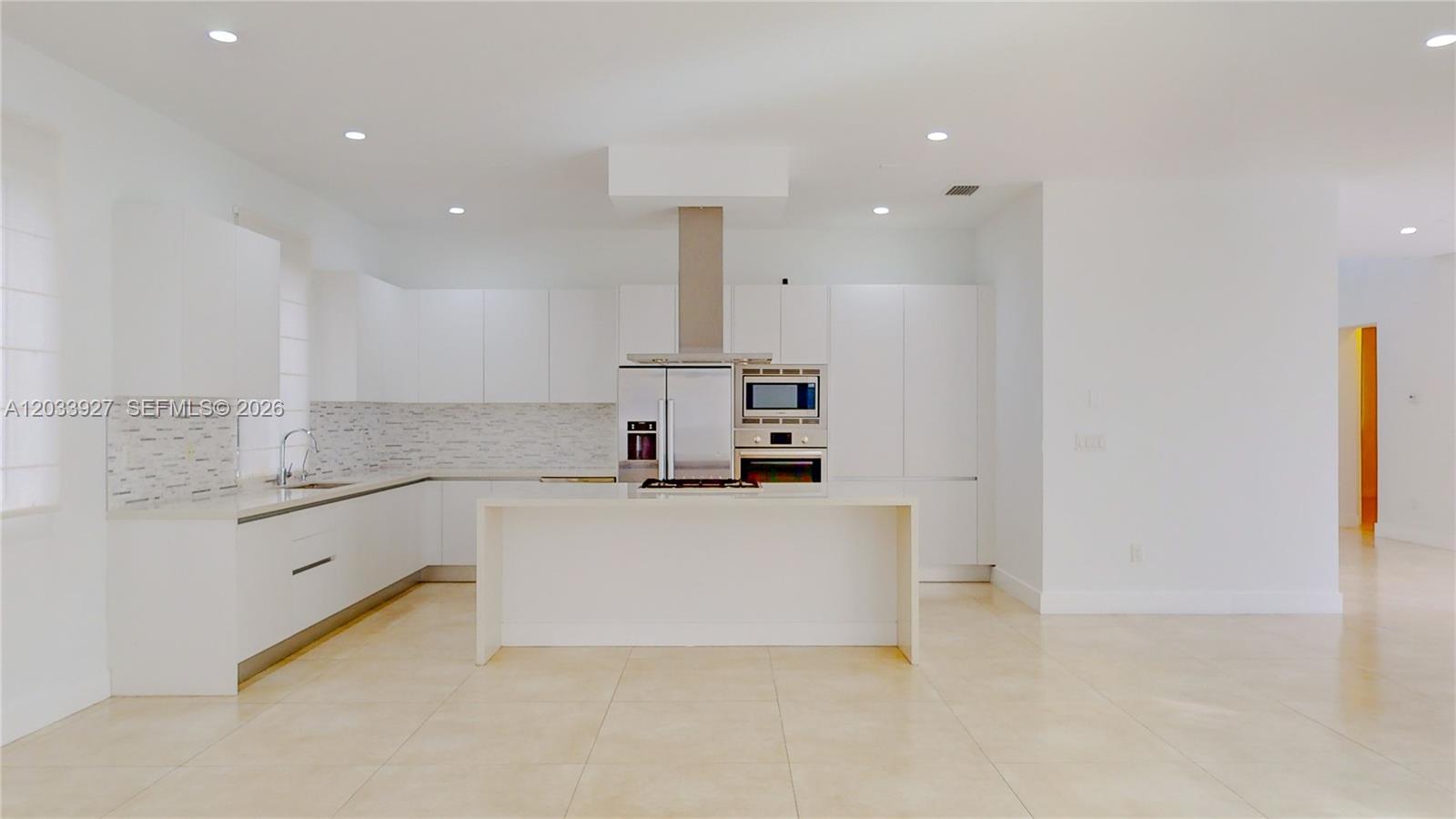 A modern white kitchen features a central island, stainless steel appliances, and tile flooring — 9980 NW 74th Ter # 9980, Doral FL 33178, DORAL, FL
